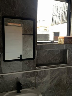 Een douche, handdoeken, zeep, toiletpapier