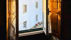 Une porte ouverte donne sur une cour intérieure, avec un bâtiment visible au fond.