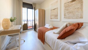 A hotel room with a bed, a desk, a chair, a potted plant, and a view of the outdoors. - Two bedroom flat-Terrace and balcony in Madrid (Madrid)