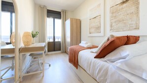 A modern hotel room with a bed, a desk, and a view of the sea. - Two bedroom flat-Terrace and balcony in Madrid (Madrid)