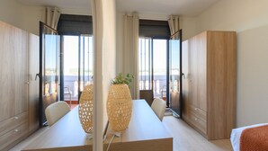 A modern hotel room with a large window, a wooden table, and a wardrobe. - Two bedroom flat-Terrace and balcony in Madrid (Madrid)