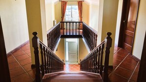 A staircase leading to a second-floor landing with a view of the outside. - Four Seasons Private Pool Huge Palace (Celorico da Beira)
