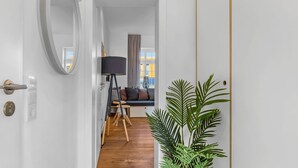 Ein modernes Wohnzimmer mit einer Couch, einer Stehlampe und einem großen Spiegel.