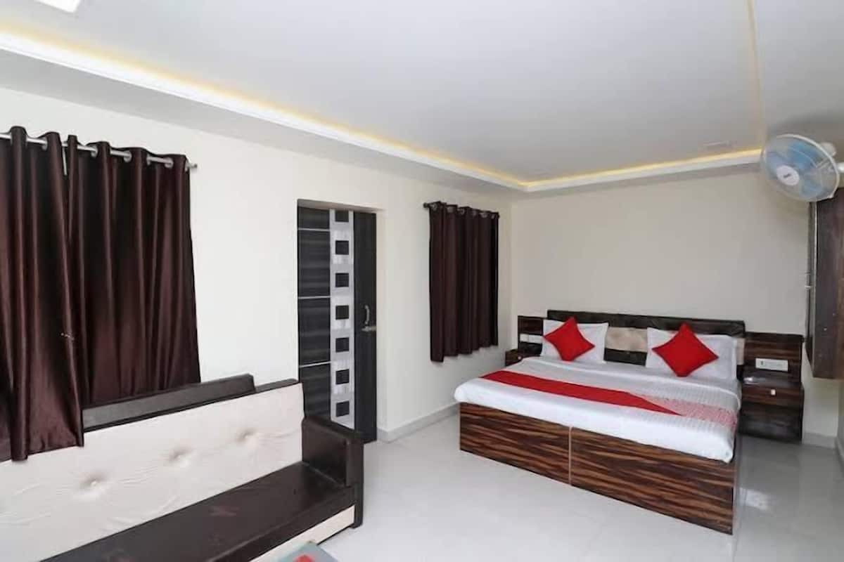 A bedroom with a bed, bedside tables, a wardrobe, and a ceiling fan.