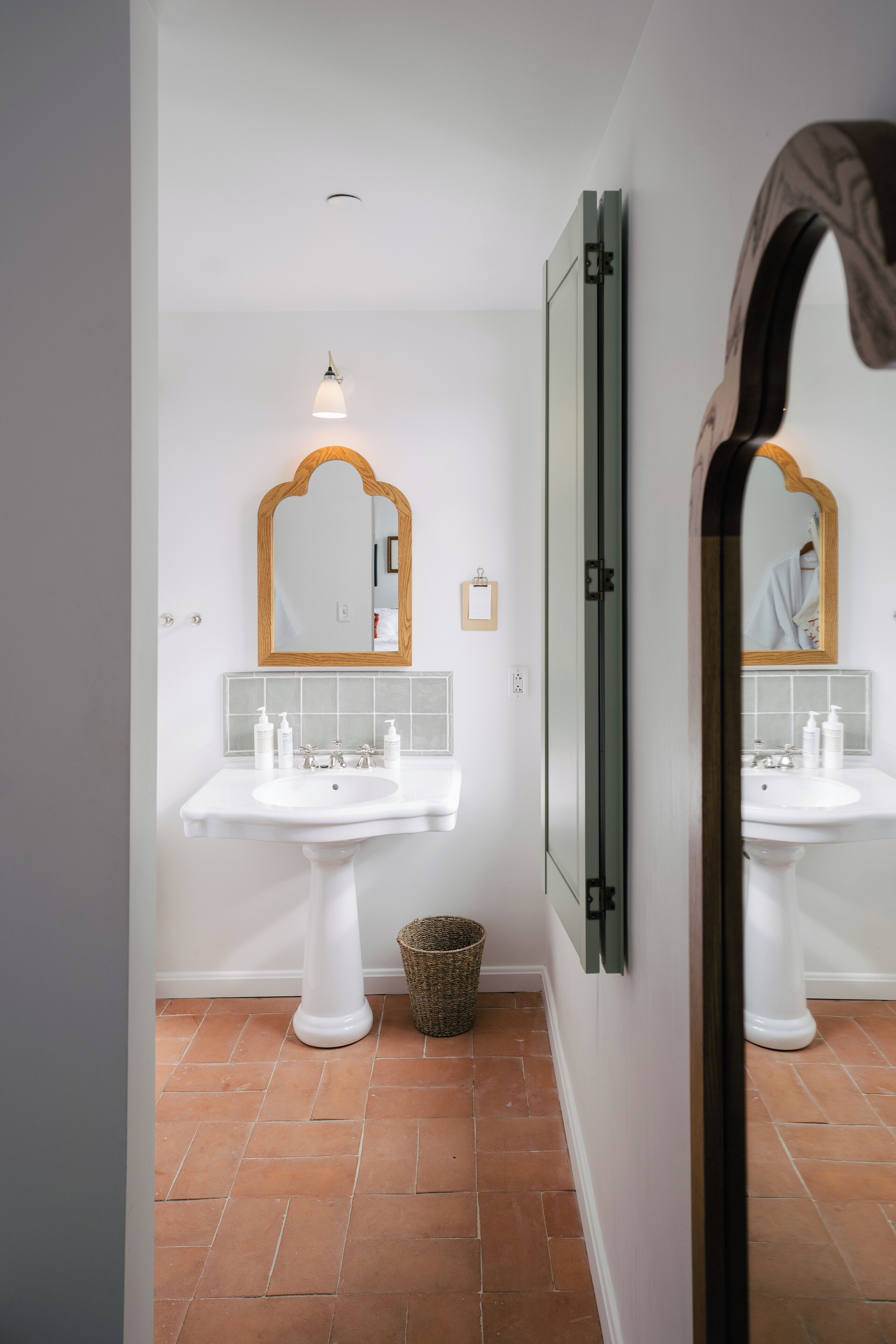 A bathroom with two white sinks, a mirror, and a ceiling light.