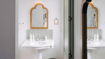 A bathroom with two white sinks, a mirror, and a ceiling light.