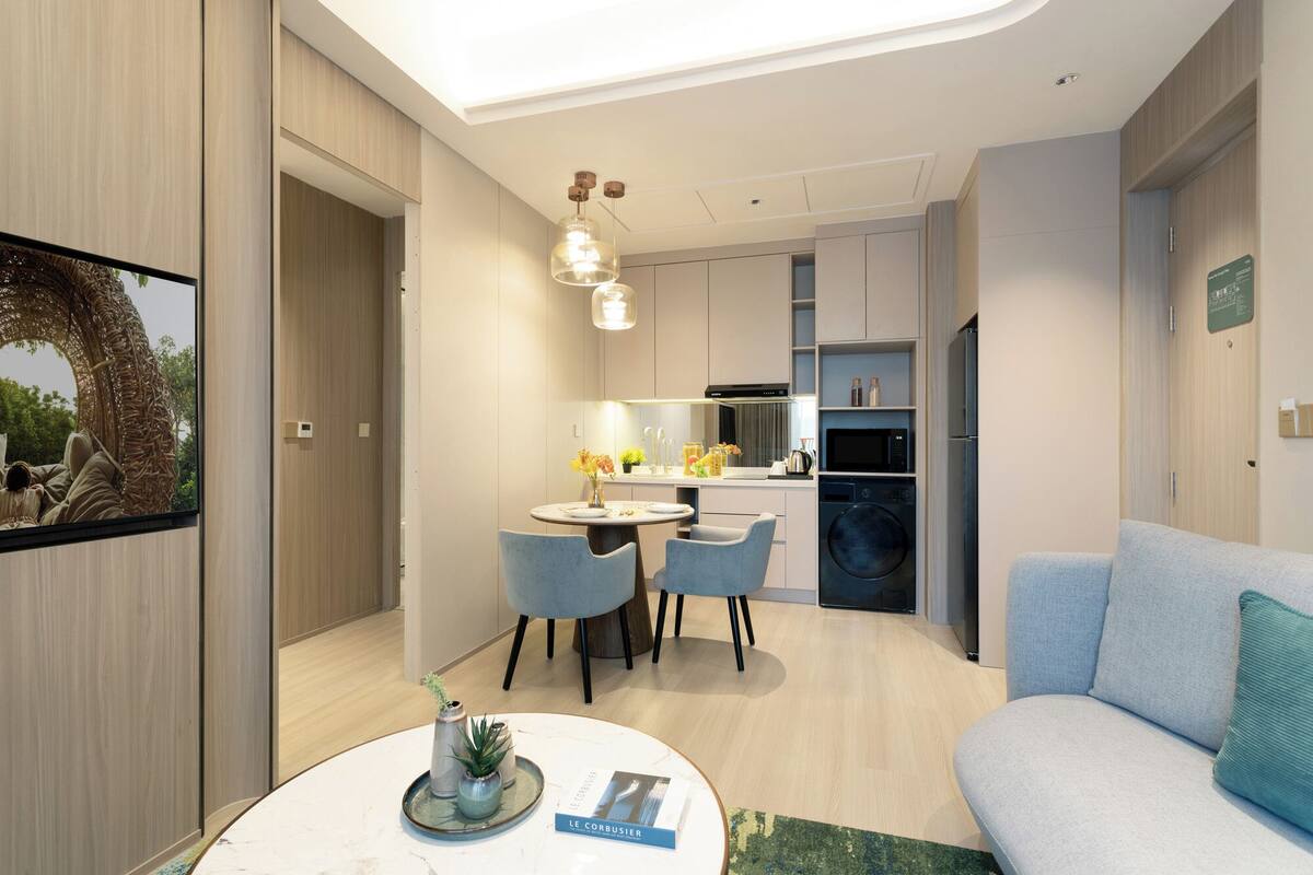 Un appartement moderne comprenant un coin repas, une cuisine et un salon.
