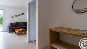 Una sala de estar moderna con un sofá gris, una mesa de centro de madera y una estantería con un logotipo.
