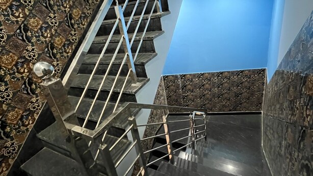 A modern staircase with a metal railing, marble walls, and a blue accent wall. - Hotel Shree Shyam Ras (Jaipur)