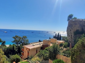 A coastal view with buildings and a cliff overlooking the sea. - Apartment for 8 with Wi-Fi, sea view (Roquebrune-Cap-Martin)