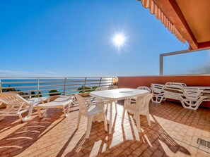 A terrace with a table and chairs, a view of the sea, and a tiled floor. - Apartment for 8 with Wi-Fi and sea view in Roquebrune-Cap-Martin (Roquebrune-Cap-Martin)