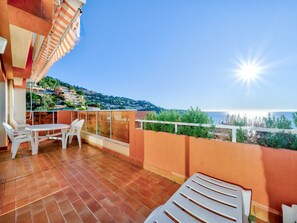 A terrace with a table and chairs, a railing, and a view of the sea and buildings in the background. - Apartment for 6 with Wi-Fi and sea view in Roquebrune-Cap-Martin (Roquebrune-Cap-Martin)