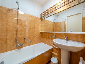 A bathroom with a bathtub, a sink, and a shower.