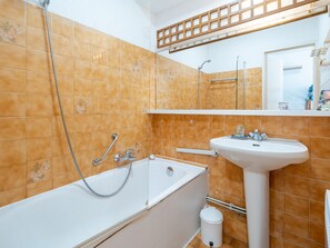 Un baño con bañera, lavamanos y retrete.