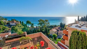 A rooftop terrace with a view of the sea, surrounded by greenery and buildings. - Lovely flat 8 people, terrace with Wi-Fi (Roquebrune-Cap-Martin)