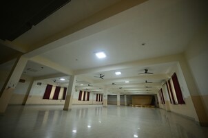 Um salão amplo e bem iluminado, com vários ventiladores de teto e iluminação embutida.