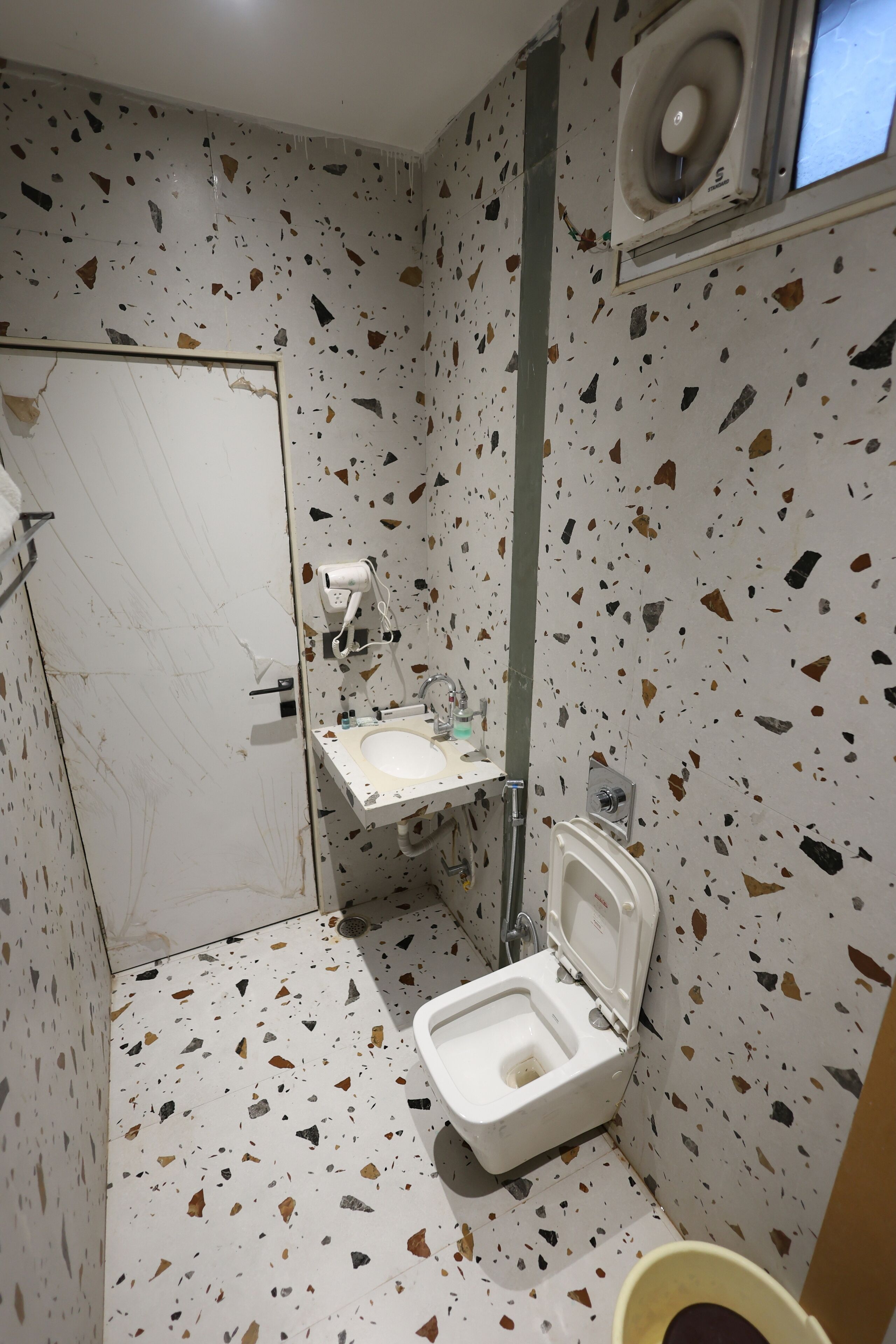 Ein Badezimmer mit einem weißen Waschbecken, einer Toilette und einem Handtrockner.