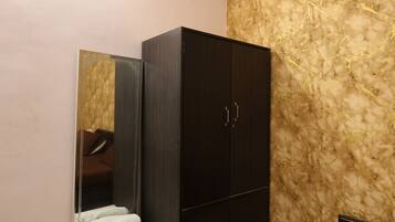 Un dormitorio con una cama, un armario, un espejo y una pared con un diseño texturizado.