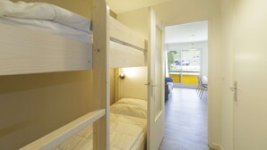 A bunk bed room with a door leading to a balcony with a view of the outside. - Renovated studio in Gourette, 4 people, pets allowed, wifi (Gourette)