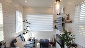 Ein gemütlicher Wohnbereich mit Sofa, Esstisch und einem Weinglas.