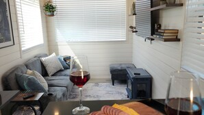 Ein gemütlicher Wohnbereich mit Sofa, Couchtisch, Kamin und Esstisch mit Speisen und Getränken.