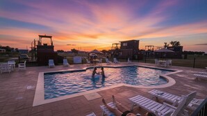 Una piscina amb gandules i una torre de socorristes al capvespre.