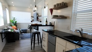 Une cuisine moderne dotée d’un plan de travail en bois, d’un four encastré et d’un coin repas avec une table et des chaises.
