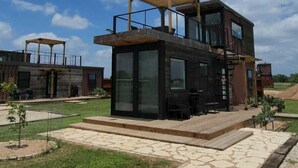 Une maison moderne à deux étages, avec un chemin en pierre menant à l’entrée.