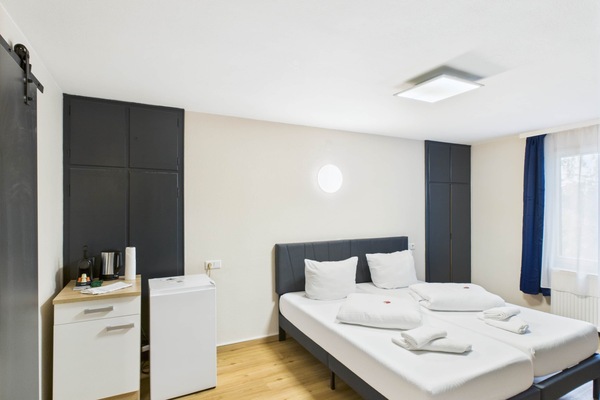 Schlafzimmer mit 2 gemütlichen Einzelbetten, Essbereich für 2 Personen, Kaffeemaschine, Kühlschrank