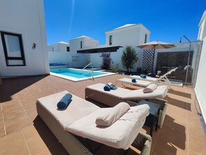A rooftop pool area with lounge chairs and a swimming pool.