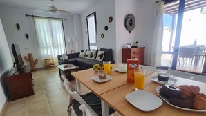 Un coin repas avec une table mise pour le petit-déjeuner, comprenant des croissants et du jus d’orange.