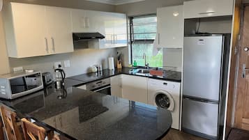 Luxe cottage | Privékeuken | Een koelkast met diepvriezer, een oven, een kookplaat, een broodrooster