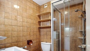 Une salle de bain avec une douche à parois de verre, un lavabo blanc et des toilettes.