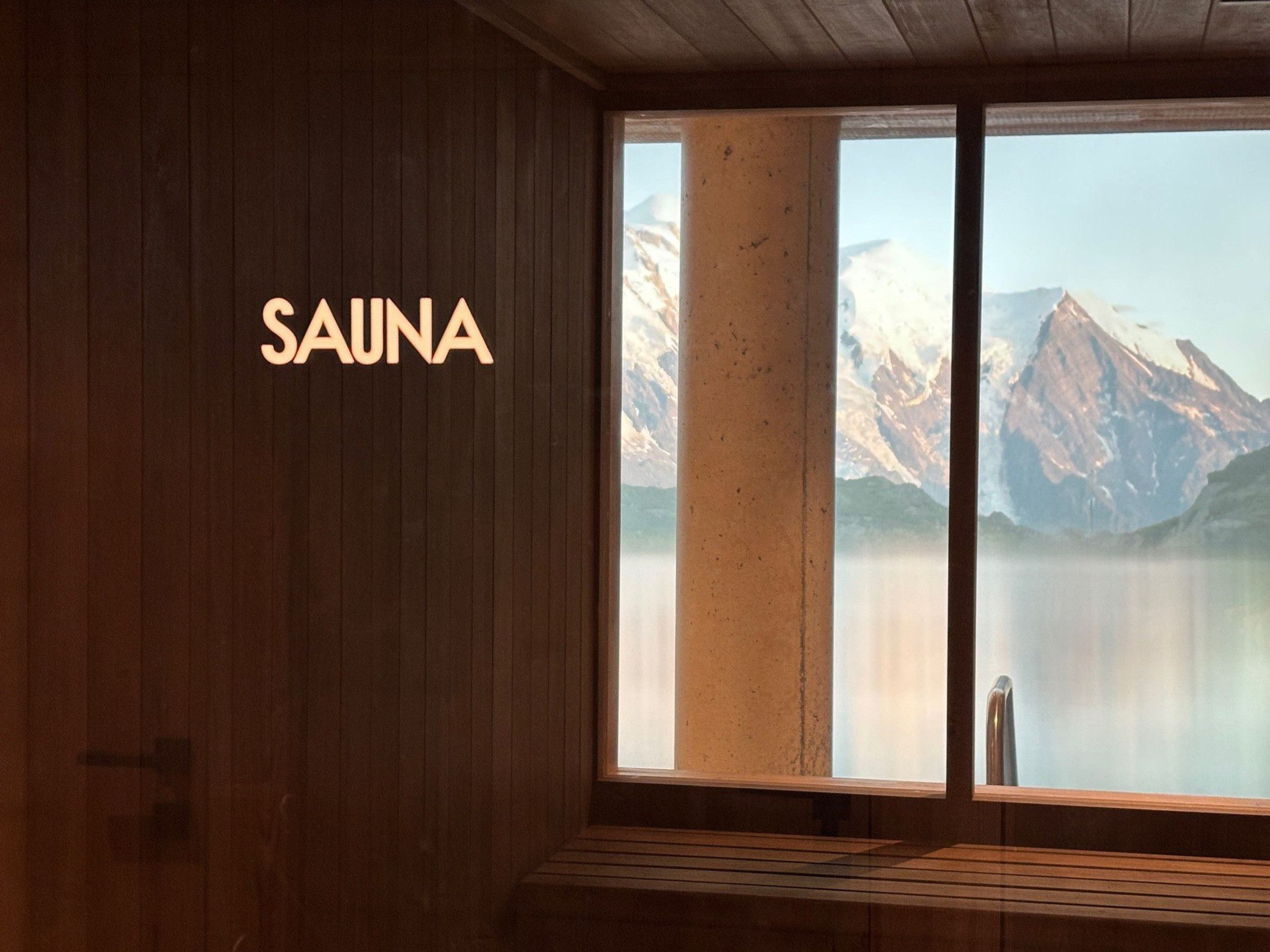 A wooden interior with a window revealing a mountain view.