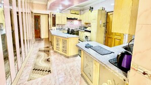 A spacious kitchen with marble flooring, wooden cabinets, and a central island. - Cozy apartment in tranquil Old Cairo with fitness room, WiFi (Egypt)