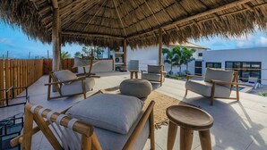 Un espace extérieur aménagé avec du mobilier en bois et un toit de chaume.