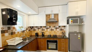 Een moderne keuken met houten kastjes, een zwart aanrecht en een roestvrijstalen afzuigkap.