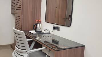 Un espacio de oficina moderno con un escritorio de madera, una silla de oficina blanca, un espejo y una lámpara en el techo.