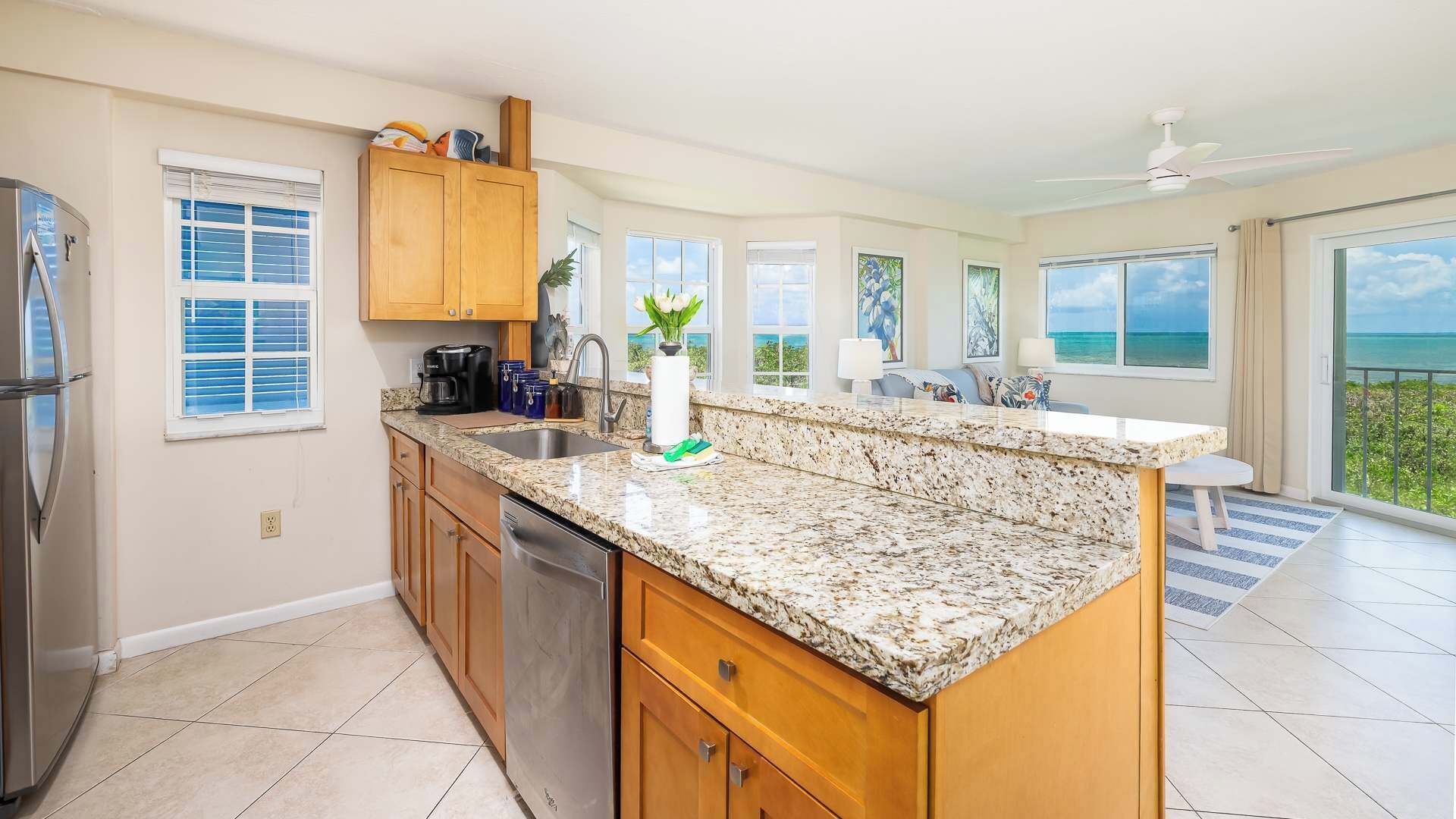 A modern kitchen with granite countertops, wooden cabinets, and a built-in dishwasher.