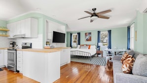 A modern kitchen with white cabinets, a central island, and a built-in oven. - Water Views, Minutes to Downtown & Folly Beach! (Charleston)