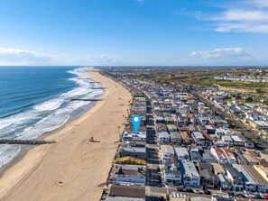 Zona residencial costera con playa, casas y una carretera.