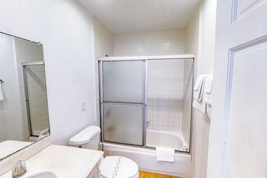 Een badkamer met toilet, wastafel en douche.