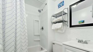 Ein Badezimmer mit Dusche, Toilette, Waschbecken und Handtuchhalter.