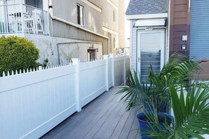 Un edificio residencial con cerca blanca, una planta en maceta y una puerta con el número 405.