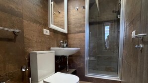 A modern bathroom with a toilet, bidet, and sink.