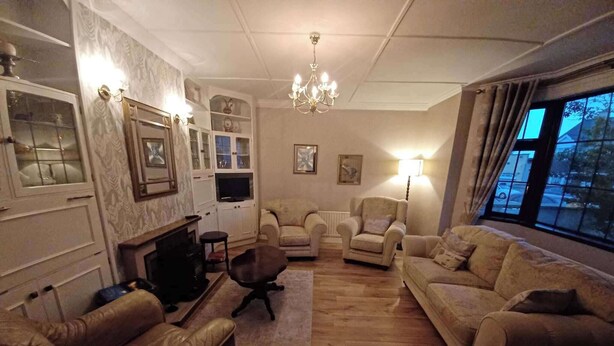 A living room with a fireplace, leather armchairs, a sofa, and a television. - Abbeyfeale Home-sleeps 6 -private Garden (Abbeyfeale)