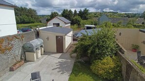 A residential area with houses, a garage, and a small garden. - Abbeyfeale Home-sleeps 6 -private Garden (Abbeyfeale)