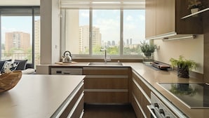 Eine moderne Küche mit großem Fenster, eingebauten Geräten und Blick auf die Stadt.