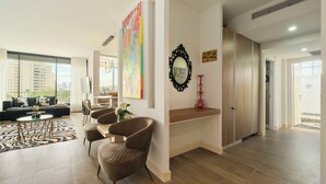 Ein modernes Wohnzimmer mit einer Couch, Sesseln, einem Couchtisch und Kunstwerken an den Wänden.