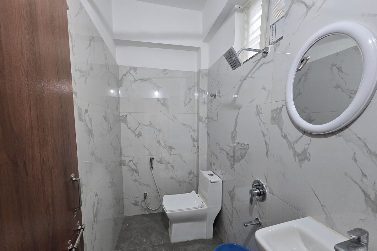 A bathroom with a toilet, bidet, sink, and mirror.